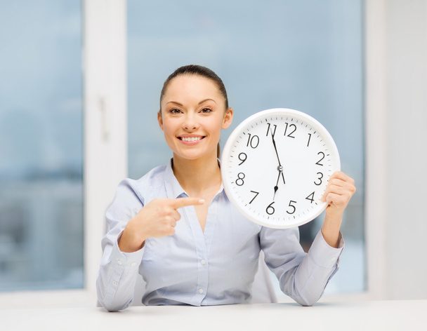 Attractive businesswoman with white clock - Фото, изображение