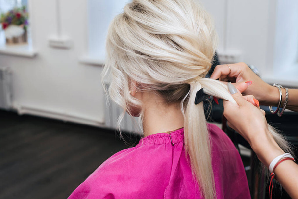 frizura zsemle egy szőke lánynak hosszú hajjal - Fotó, kép