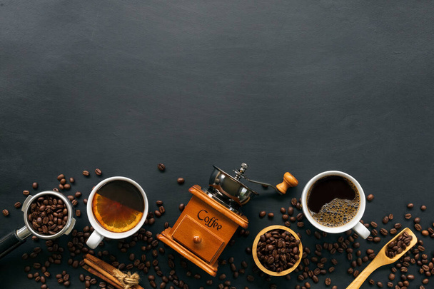 горячий кофе, фасоль и ручная мельница на черном фоне стола. пространство для текста. вид сверху - Фото, изображение
