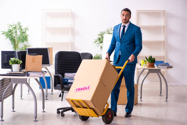 Young male employee in moving concept - 写真・画像
