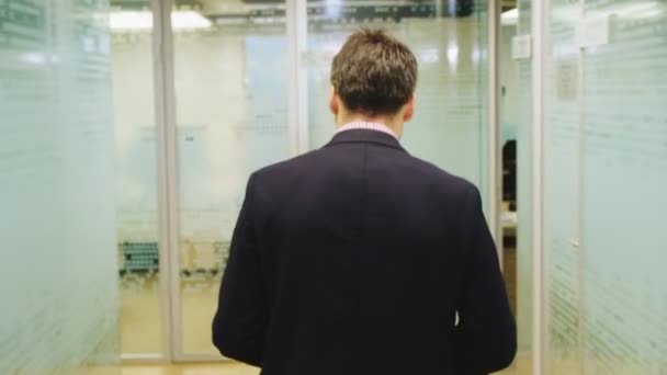 worker walks along hallway to workplace in modern office - Video