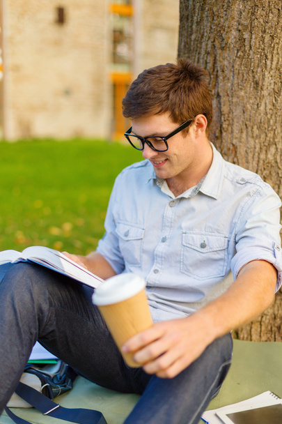 Teenager reading book with take away coffee - Foto, imagen