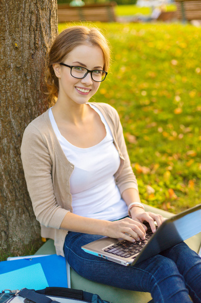 Smiling teenager in eyeglasses with laptop - Valokuva, kuva