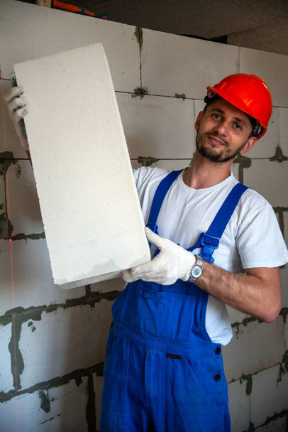 Master foreman puts a wall of aerated concrete blocks when building a house. Private housing construction. Modern technologies and materials for construction of aerated concrete blocks. - Photo, Image
