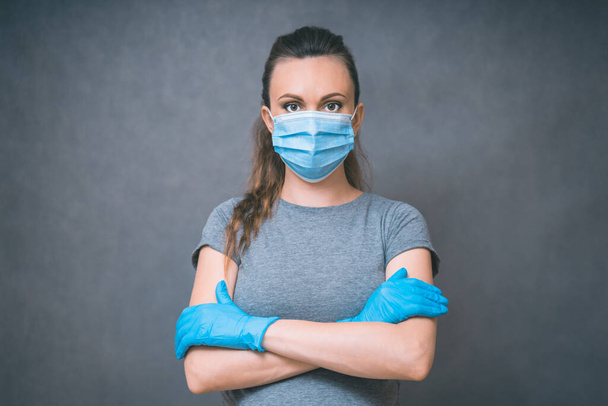 Yang woman in blue gloves and Medical Face Mask against flu and viruses. Healthcare And Infection concept. - Фото, зображення
