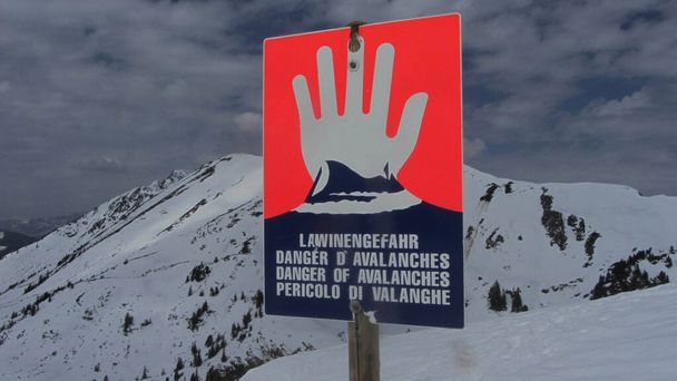 雪山で雪崩警報標識の赤い危険性-ドイツ語、英語、フランス語、イタリア語 - 写真・画像
