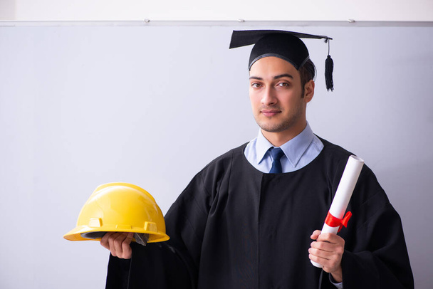 Young male graduate in front of board - Photo, Image