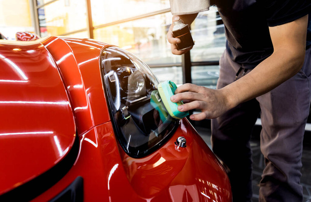 Car service worker applying nano coating on a car detail - Foto, imagen