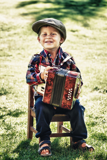 Felice giovane ragazzo che suona la fisarmonica in estate
 - Foto, immagini