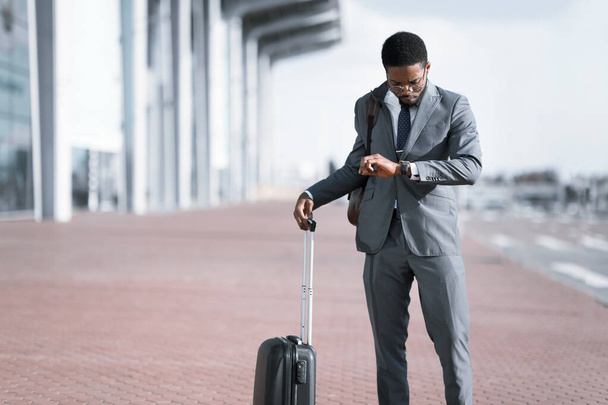 Бизнесмен с чемоданом для путешествий ждет задержки рейса в аэропорту - Фото, изображение
