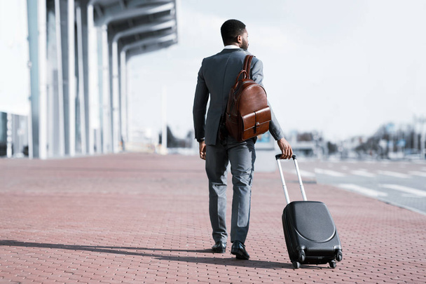 Un homme d'affaires en voyage d'affaires arrivant à l'aéroport, vue arrière - Photo, image