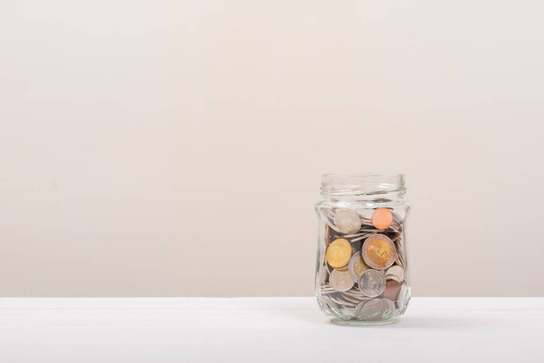 Mince ve sklenici nebo skleněné láhvi s měkkým bílým pozadím. Úspora peněz, Úspora konceptu - Fotografie, Obrázek