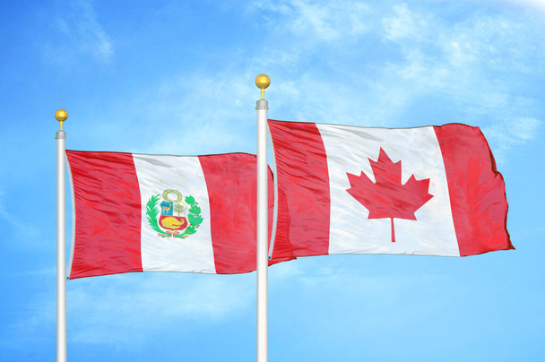 Перу и Канада два флага на флагштоках и голубом облачном фоне неба - Фото, изображение