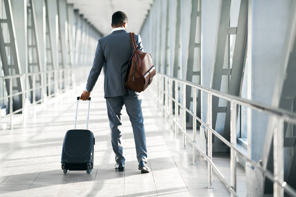 Empresário afro-americano que caminha de volta para a câmera no aeroporto interior
 - Foto, Imagem