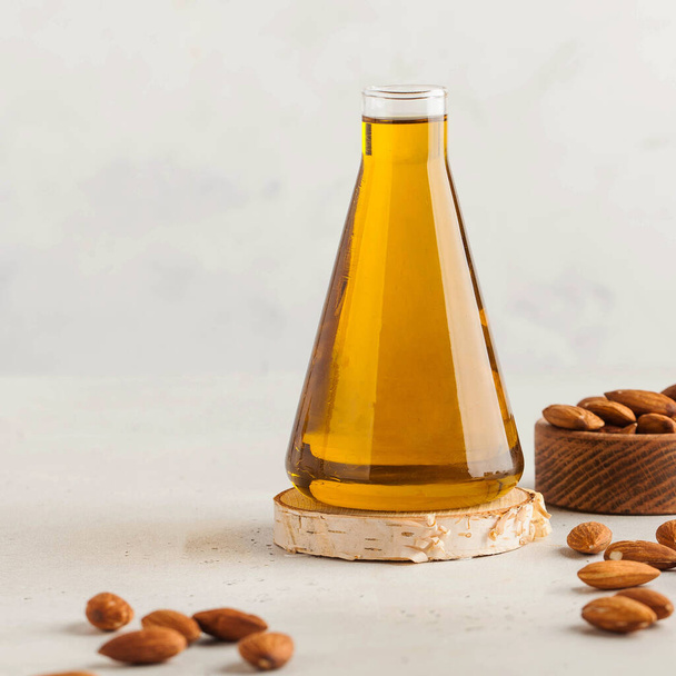Almond vegetable oil in a flask with almond nuts around. The concept of healthy eating. Copy space. High quality photo - Fotoğraf, Görsel