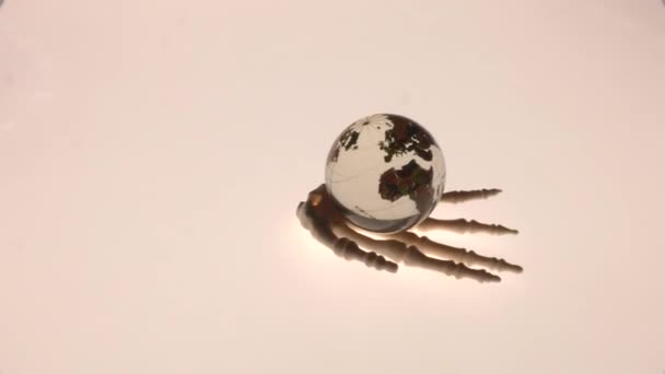 Globus w rękach szkieletowego symbolu Apokalipsy. - Materiał filmowy, wideo