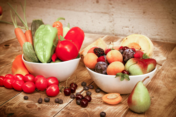 Zdrowe świeże organiczne wegetariańskie jedzenie, owoce i warzywa w misce na rustykalnym stole - Zdjęcie, obraz