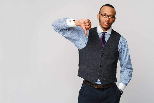 young black businessman with a dissenting serious dislike expression with thumbs down in disapproval - Photo, Image