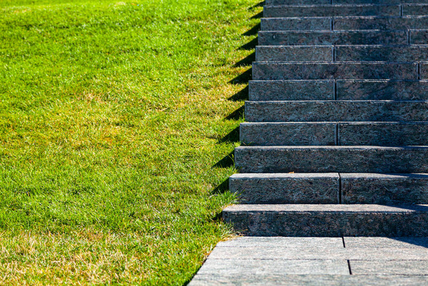 Stone stairs and lawn, close up. Gray steps and grass in the park, fragment. - Foto, imagen