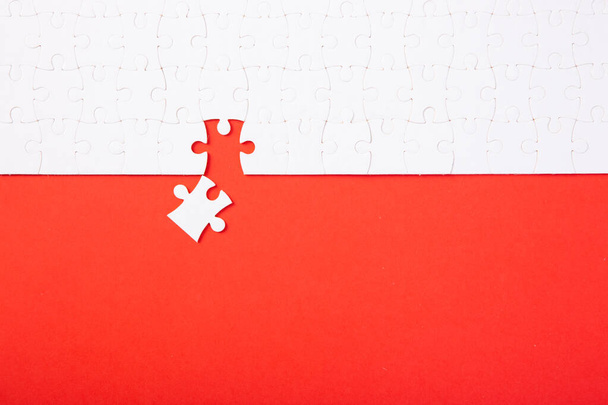 Blank white puzzle pieces on red background, flat lay. Space for text - Photo, Image