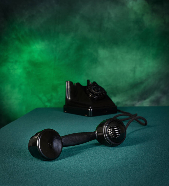 Black old retro telephone on green cloth - Photo, image