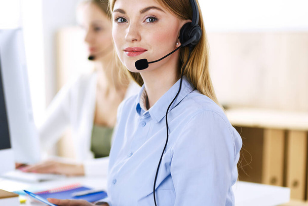 Portrait of call center operator at work. Group of people in a headset ready to help customers. Business concept - Photo, Image