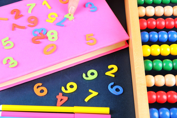 Colorful numbers, abacus, books and markers on school desk background - Photo, Image