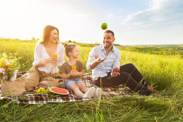 Щасливий тато жонглювання з яблуками на пікніку на відкритому повітрі
 - Фото, зображення