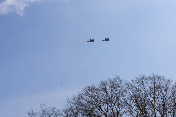 遠くの曇天の春の空に2機のロシアの軍用機 - 写真・画像