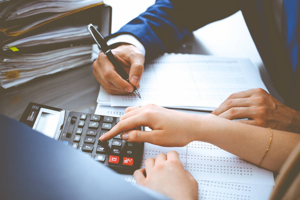 Bookkeeper or financial inspector and secretary making report, calculating or checking balance. Internal Revenue Service inspector checking financial document. Business, tax and audit concepts - Fotografie, Obrázek