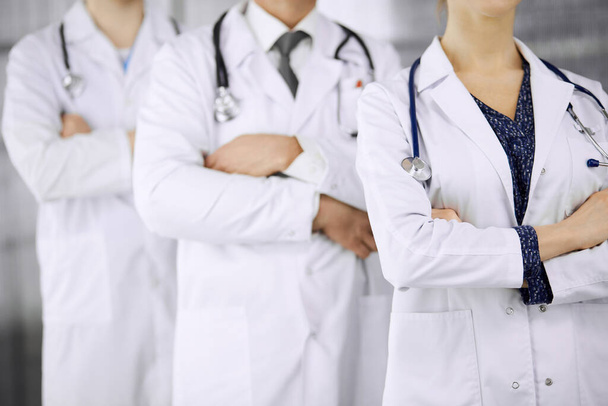 Doctors standing as a team with arms crossed in clinic. Medical help, insurance and medicine concept - Foto, immagini