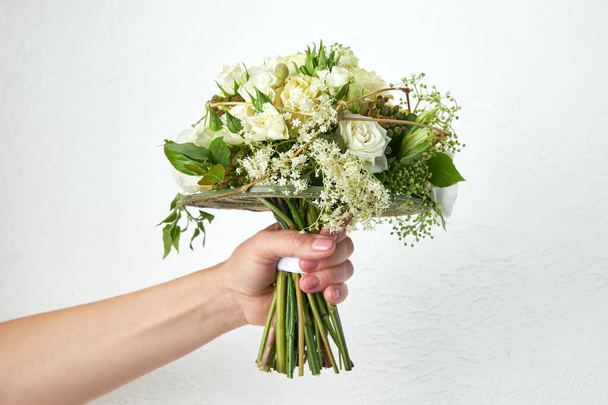 Bouquet de mariage vert dans les mains de la femme sur fond blanc - Photo, image