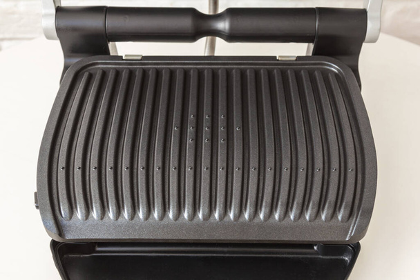 Ridge teflon surface of an electric grill. Close-up view of barbecue for home use. - Fotoğraf, Görsel