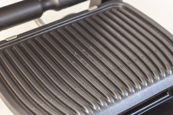 Ridge teflon surface of an electric grill. Close-up view of barbecue for home use. - Foto, Imagem