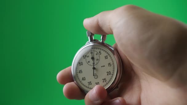 Male hand holding analogue stopwatch on green screen chroma key. Time start with old chronometer man presses start button in the sport concept. Time management concept. - Footage, Video