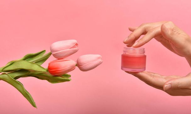 Natural skincare garrafa rosa, Mão aplicar embalagens recipientes cosméticos com extrato de essência de flor de tulipa, conceito de produto de beleza orgânica
. - Foto, Imagem