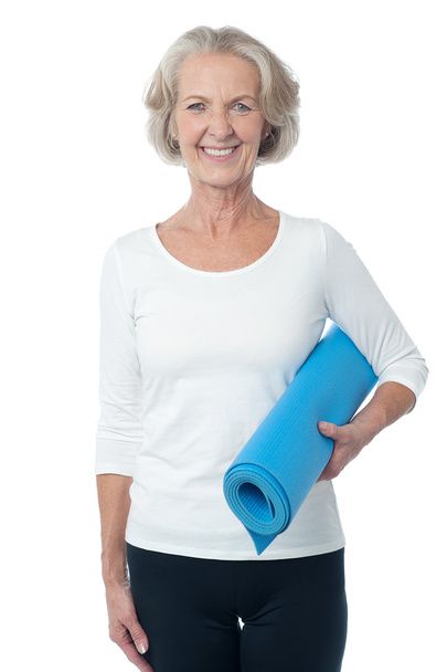 Gym instructor holding blue exercise mat - Foto, afbeelding