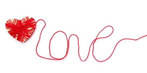 Hearth and word Love made with red thread isolated on white background - Фото, изображение