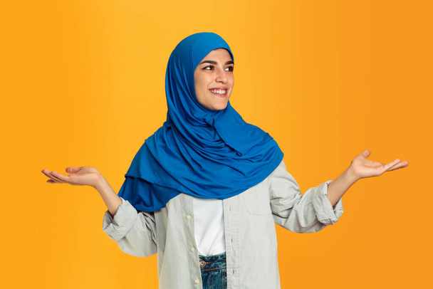 Portrait of young muslim woman isolated on yellow studio background - Fotó, kép