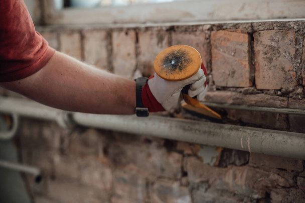 Builders strong hands working with hammer and chisel at the construction site - 写真・画像