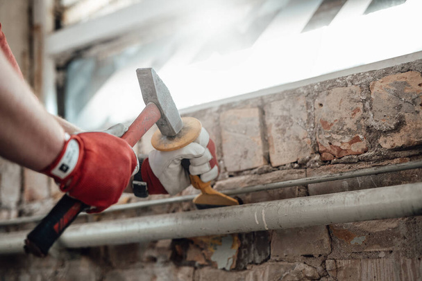 Будівельники сильні руки, що працюють з молотком і стамескою на будівельному майданчику
 - Фото, зображення