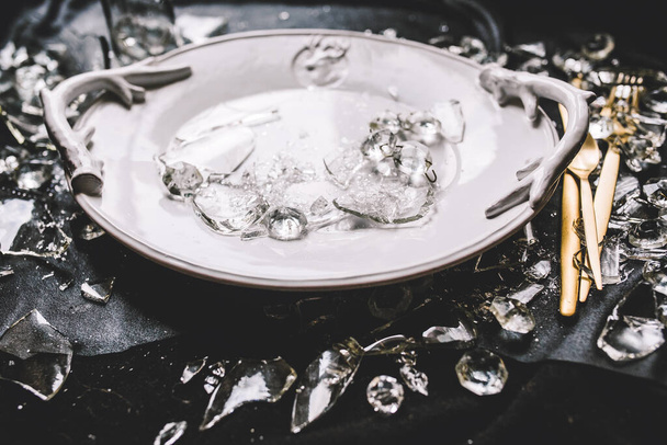 plate, golden utensils, crystals and broken glass on black background - Foto, Imagem