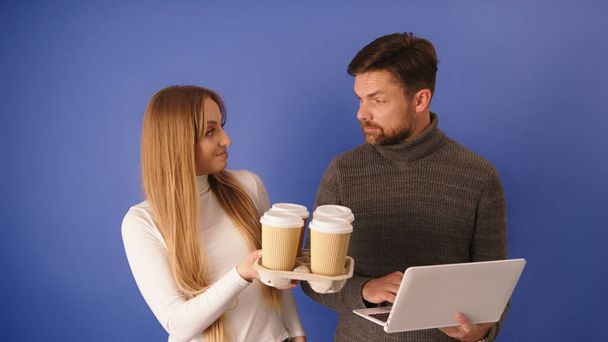 Prenditi una pausa. Donna che porta via tazze di caffè da asporto a un collega con computer portatile - Foto, immagini