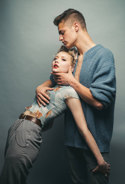 Affectionate couple while a photo session. Relax. Tender picture of young couple. Fashion studio photo of beautiful couple. Valentines day. Sensuality. Isolated on grey. - Fotografie, Obrázek