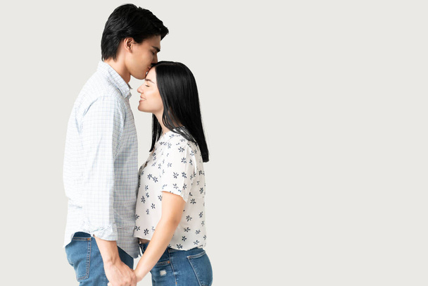 Komea nuori mies kädestä tyttöystävä suutelee otsaansa - Valokuva, kuva