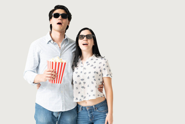 Surprised boyfriend and girlfriend watching movie and having popcorn - Photo, Image