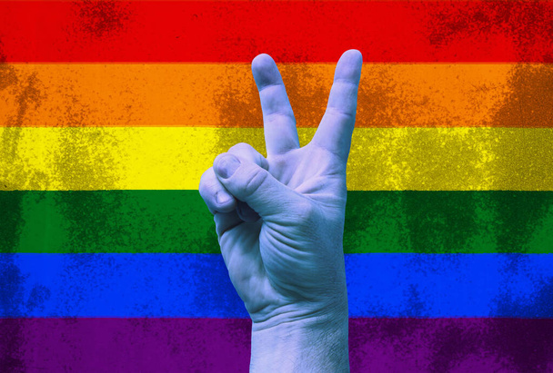 LGBT. Victory gesture on a rainbow background on the texture. Template. Content for the designer. - Photo, Image