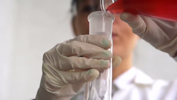Scientist pouring chemicals into flask - Filmagem, Vídeo