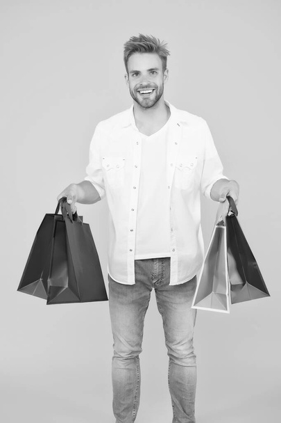 Best way to relax. How to save money while sale. cyber monday concept. goods for men. guy happy about his purchase. successful shopping online. male shopper hold packages. shopping bag with goods - Фото, изображение