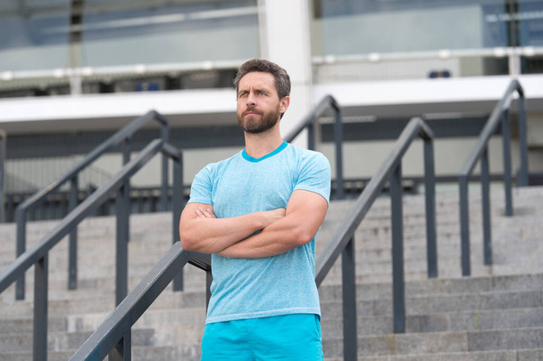 Handsome athlete beard man standing confidently. Staying fit and healthy. having a good sport shape. he is always in great shape. serious bearded man crossed hands. feeling confident and successful - Foto, Bild